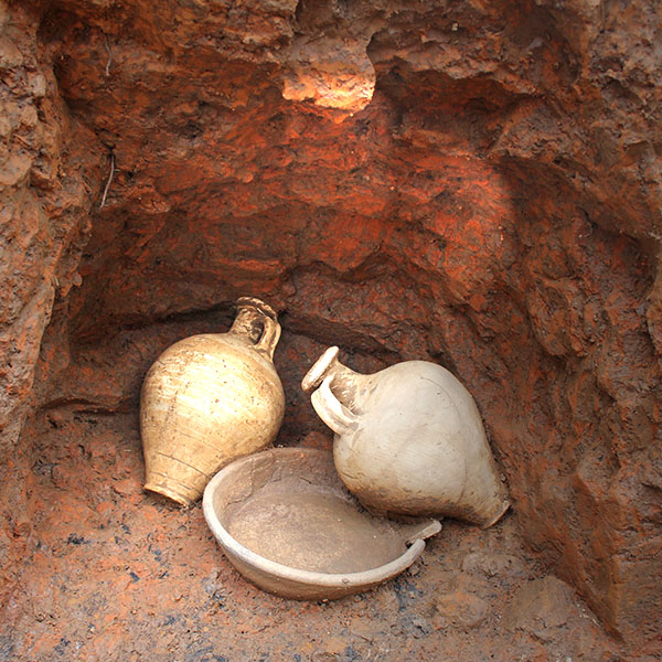 Freigelegte Nische des Bustum mit zwei Krügen und einem Teller als Sekundärbeigaben nach der Verbrennung des Toten